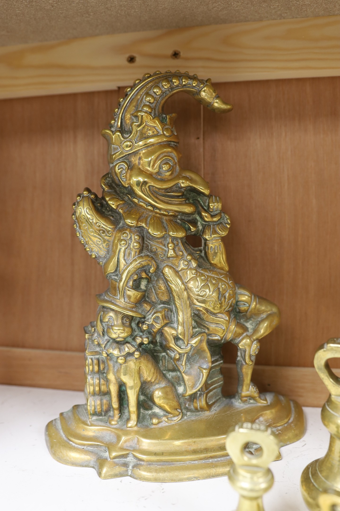 A graduated set of twelve brass bell weights and a cast brass “Punch’’ door stop. 30cm